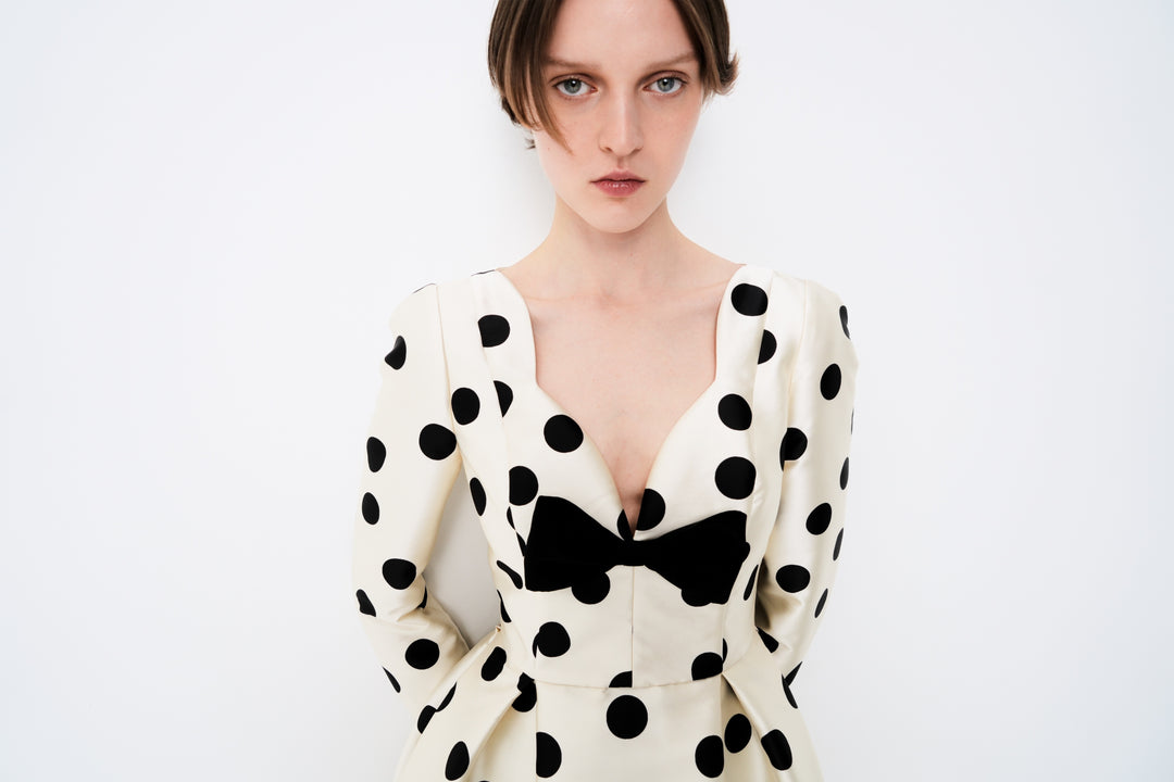 Polka-dot dress with a sculptural neckline and bow