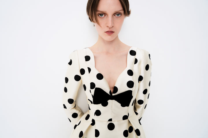 Polka-dot dress with a sculptural neckline and bow