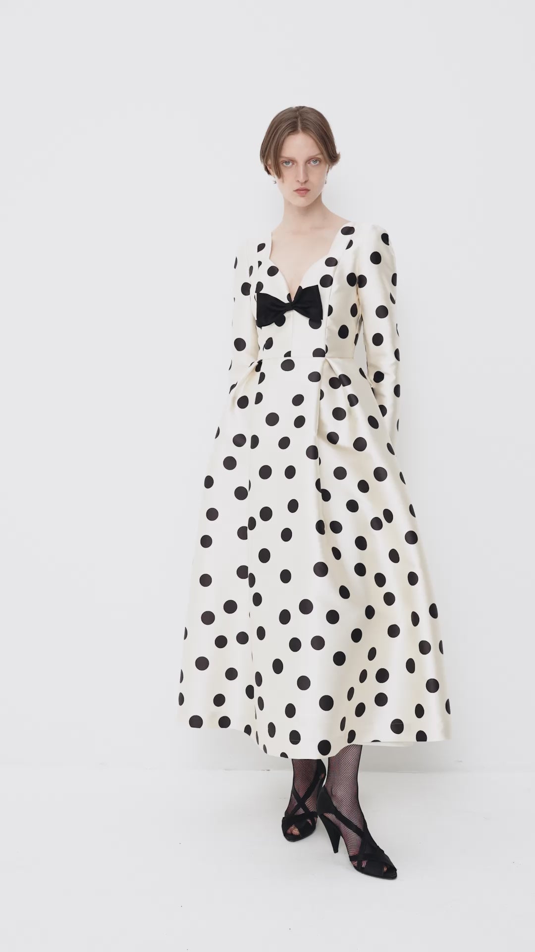 Polka-dot dress with a sculptural neckline and bow